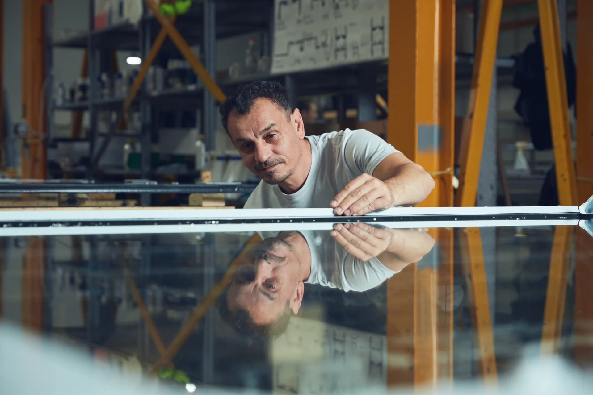 Maxlight team member inspecting architectural glass inside the Acton workshop