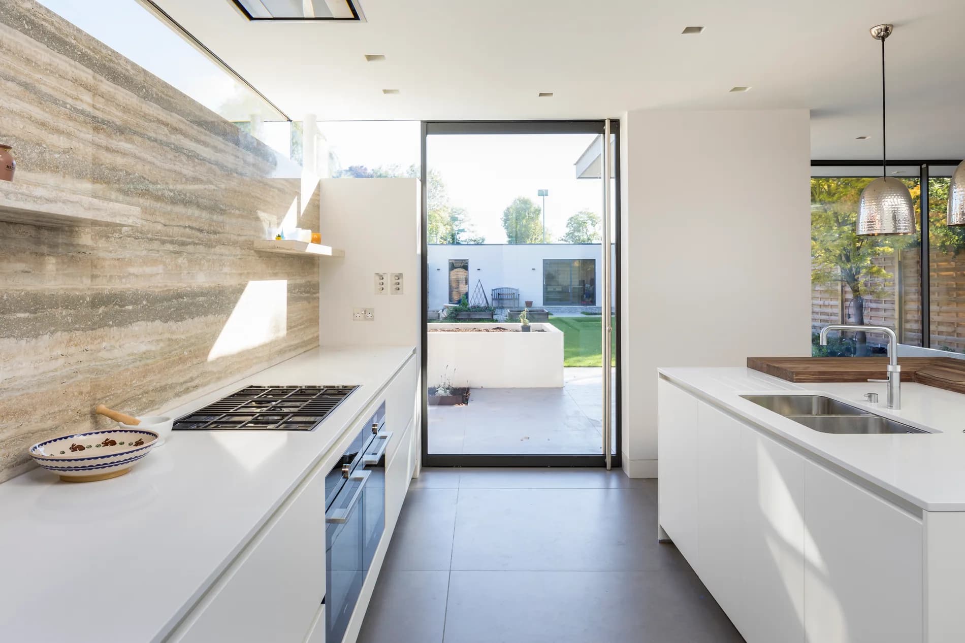 S-Max aluminium pivot door viewed through a bright kitchen towards a garden