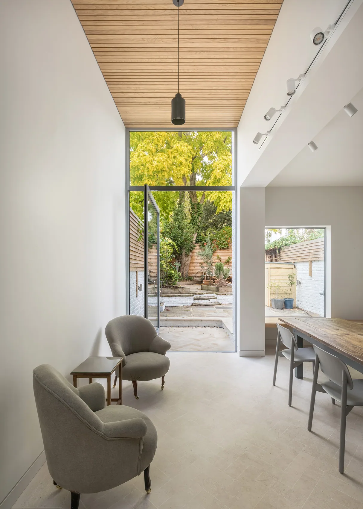 X-Max steel-framed pivot door in a tall contemporary interior