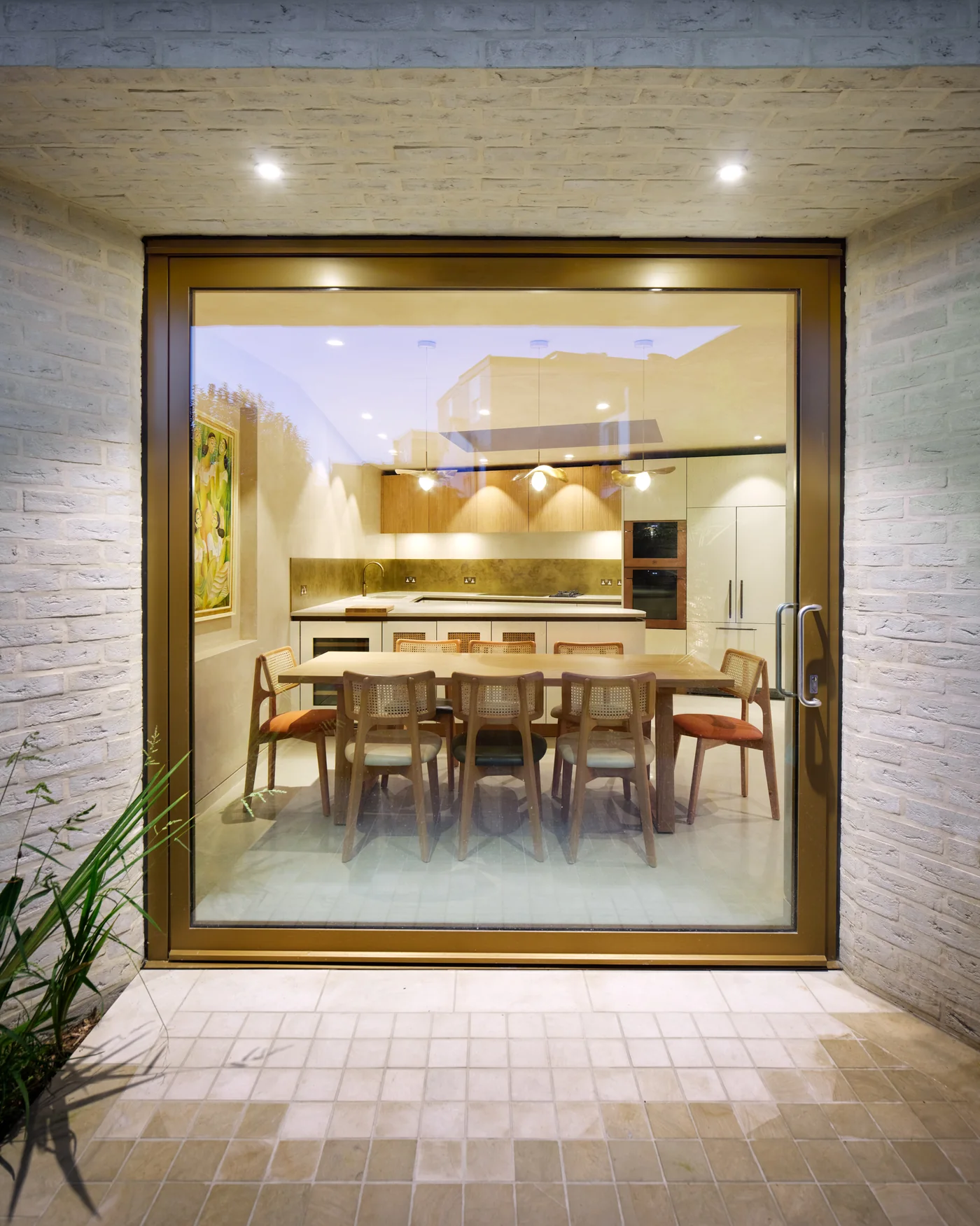 Full-height glazed pivot door with a vertical pull handle on the right