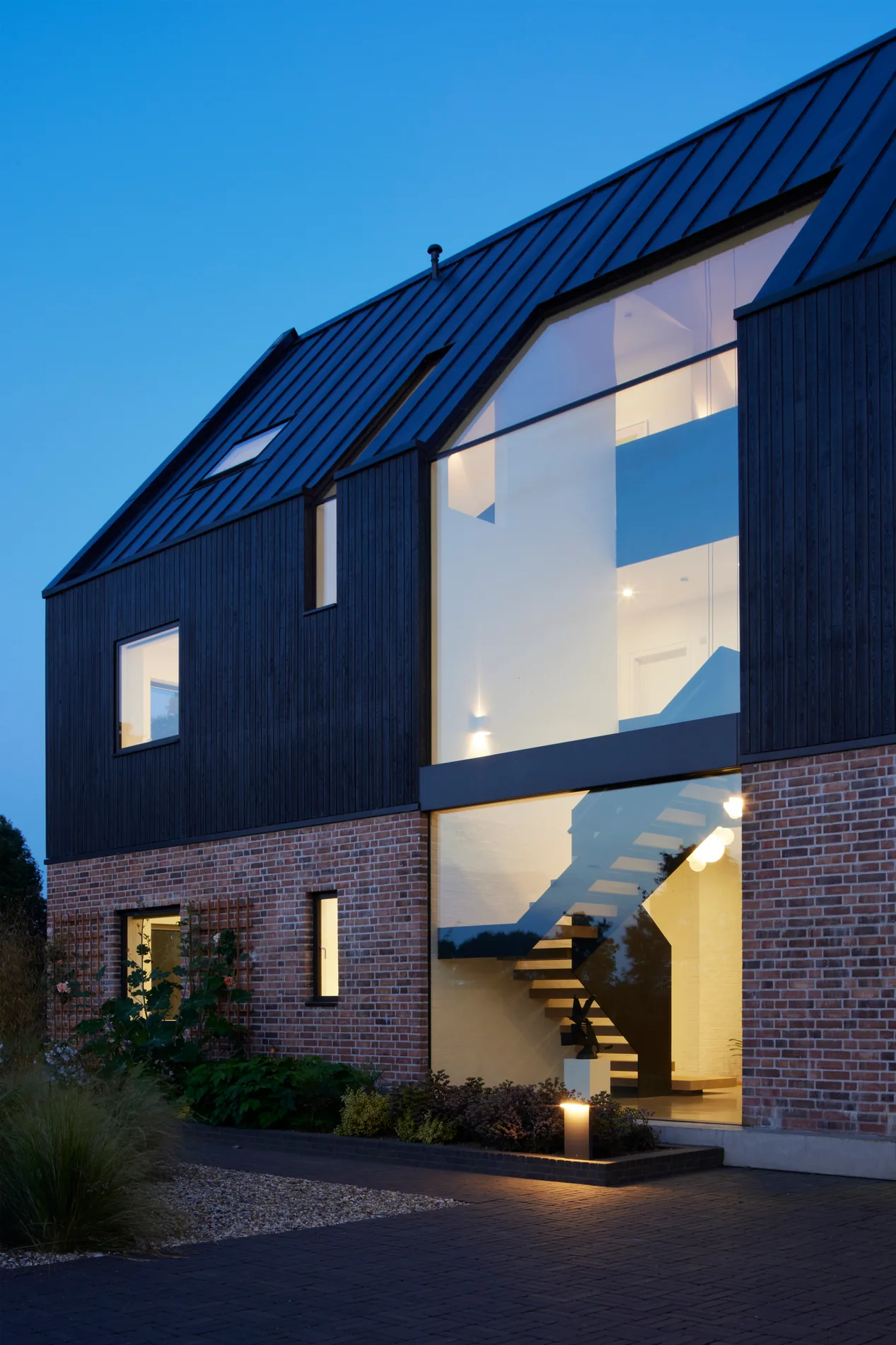 Up-and-over glazing running through the roof and facade of a contemporary brick home