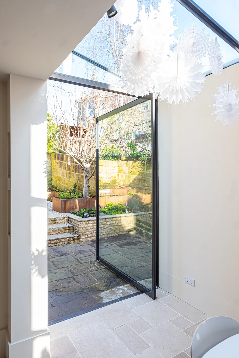 Bright rear extension with lean-to glazing above a garden doorway