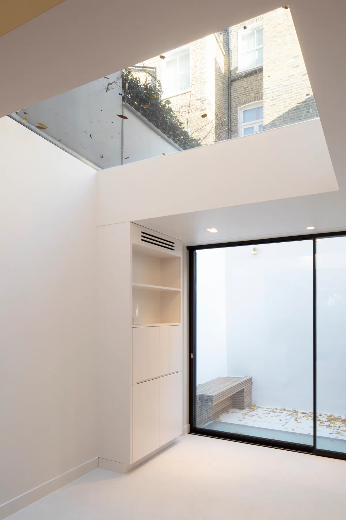 Double-height interior with a concealed Skymax rooflight above sliding doors