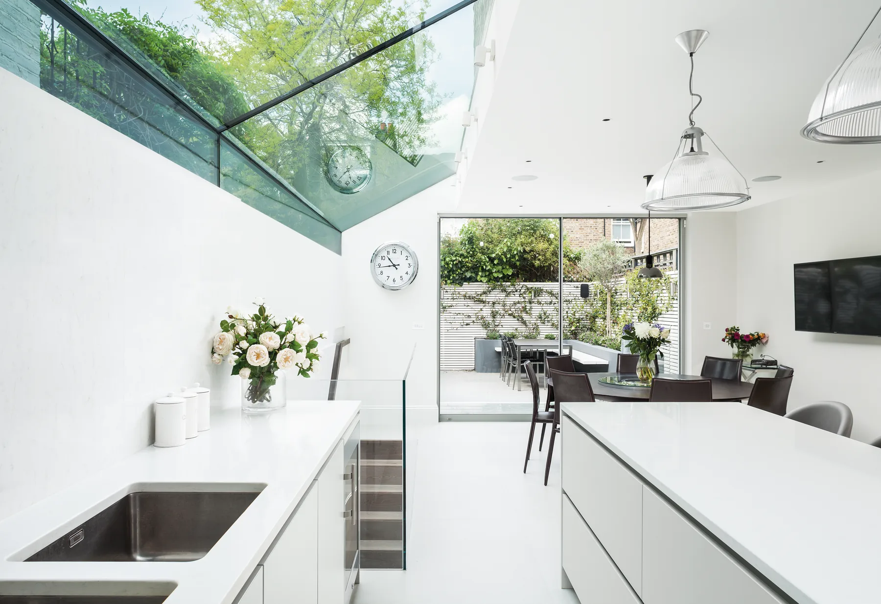 Kitchen island and pendant light below an overhead rooflight