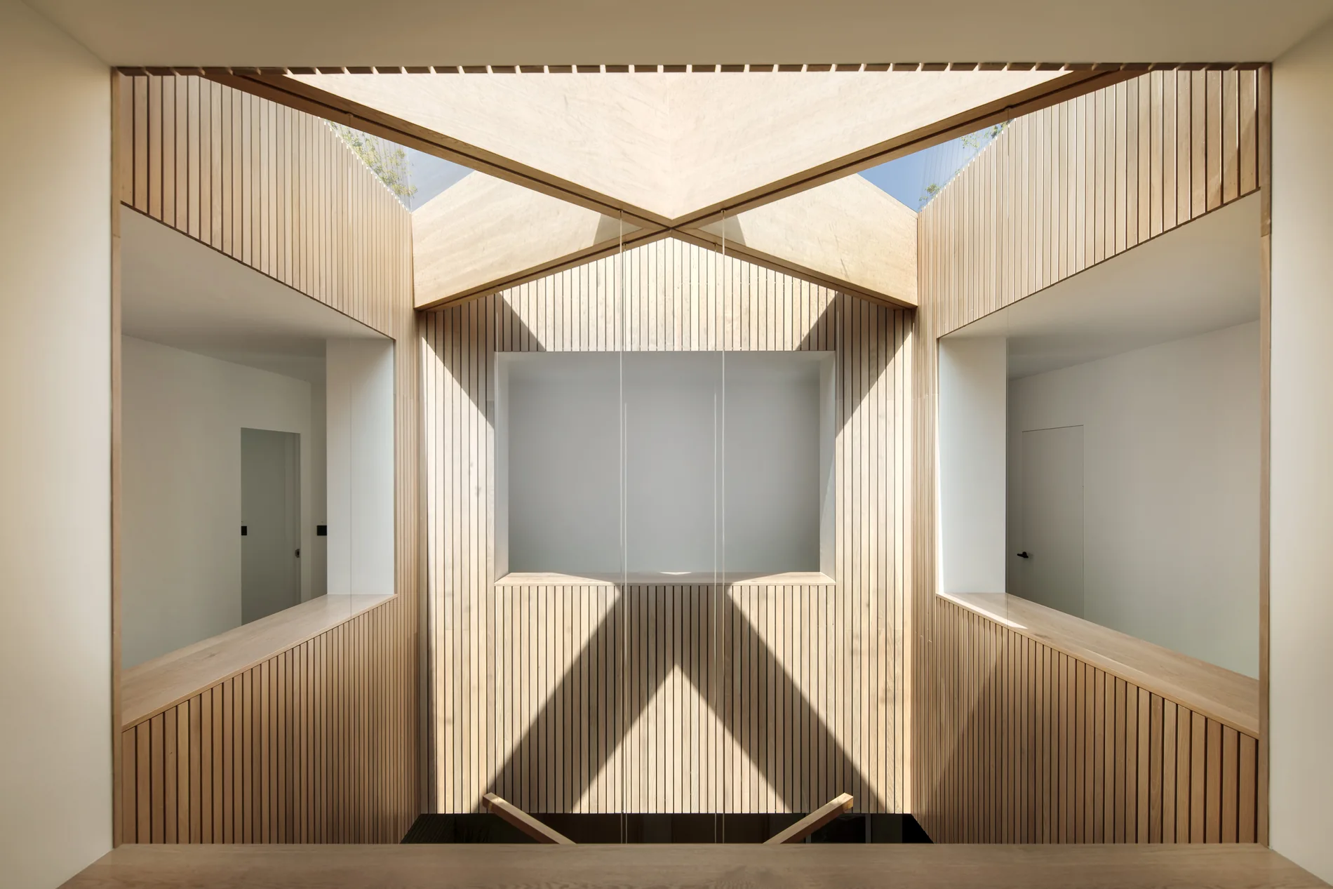 Aluminium rooflight above a bright timber-lined interior void