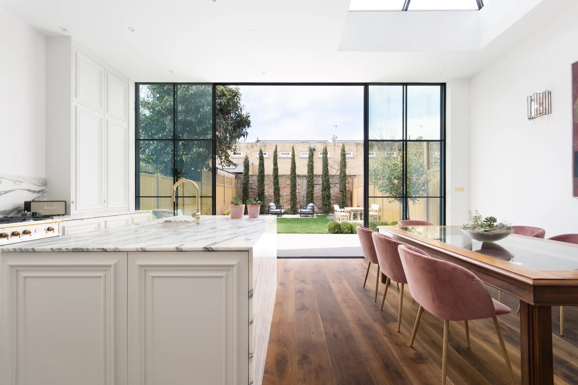 Centre-opening multi-panel sliding doors in a kitchen and dining extension