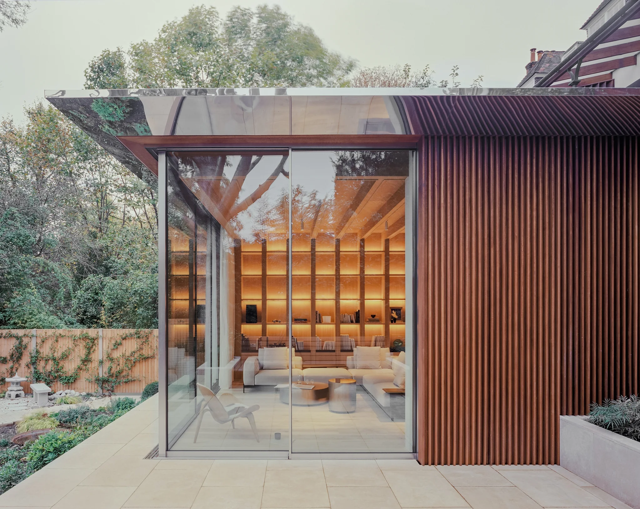 Slim aluminium glazing wrapping the corner of a contemporary timber-clad garden extension