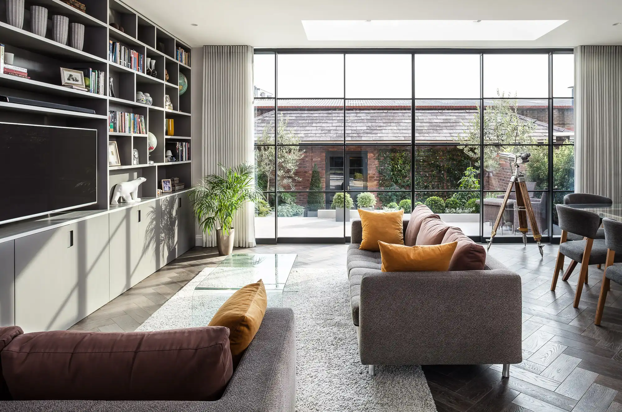 Wide multi-panel glazed elevation viewed from a contemporary living room