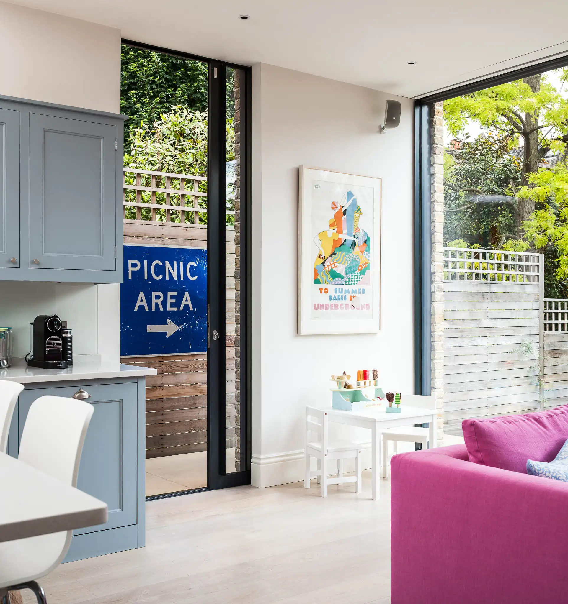Slim aluminium sliding door beside a wide open garden threshold in a family kitchen