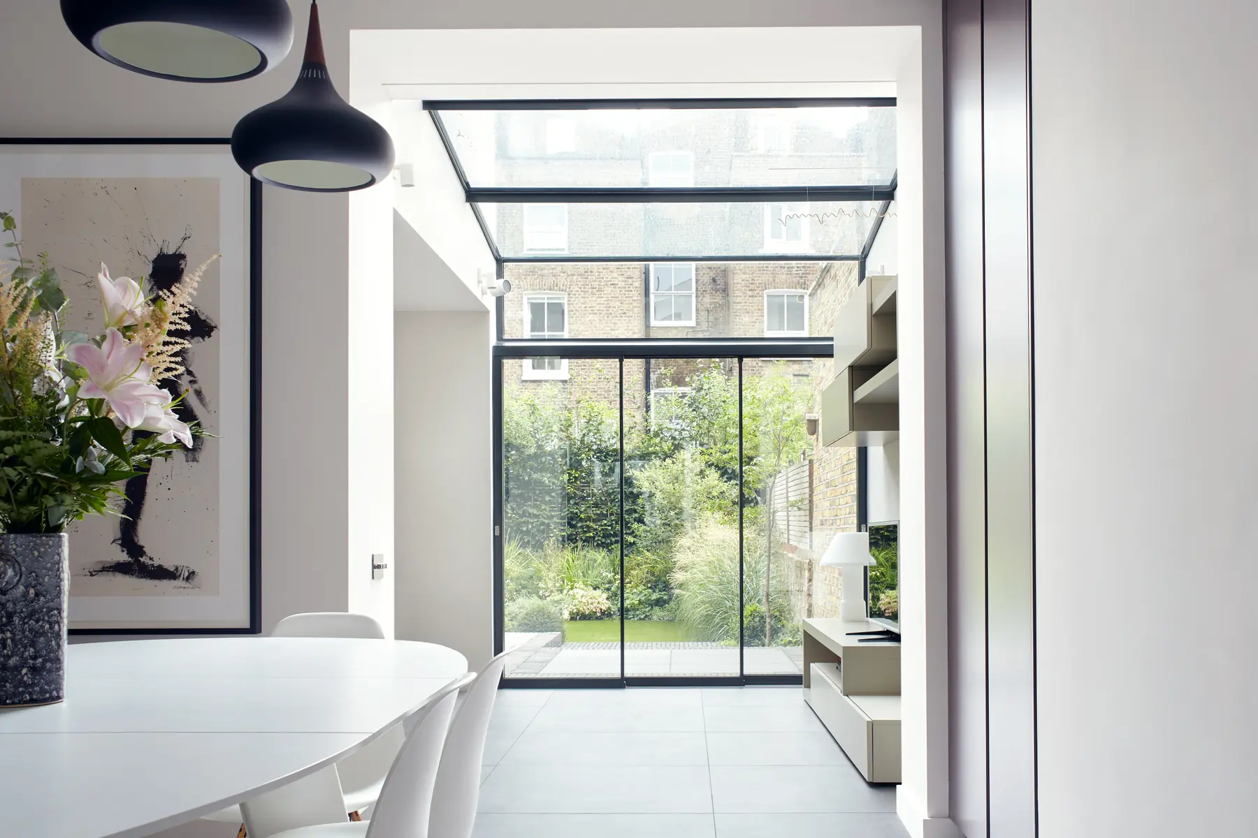 Kitchen interior with structural glass roof and large garden-facing glazing