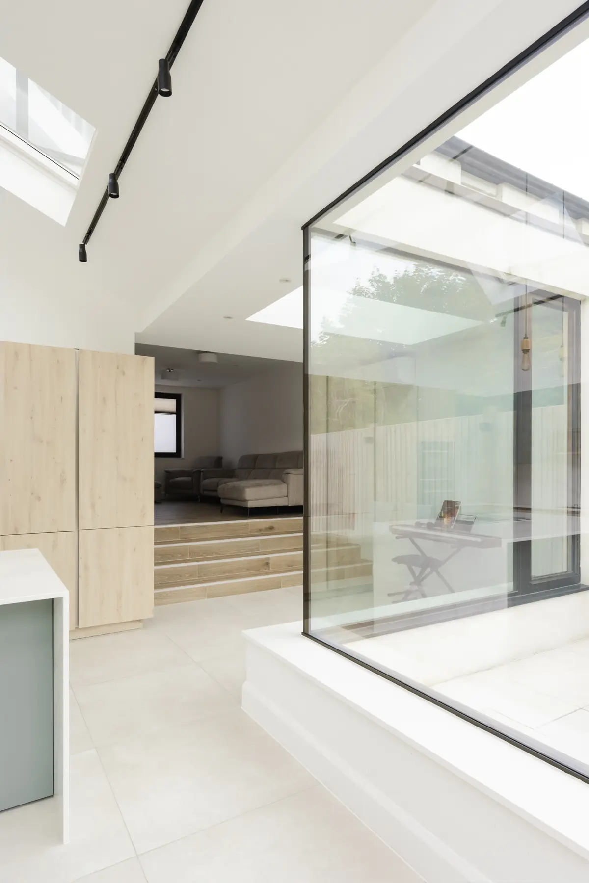 Interior glass-to-glass corner beside steps and a rooflight
