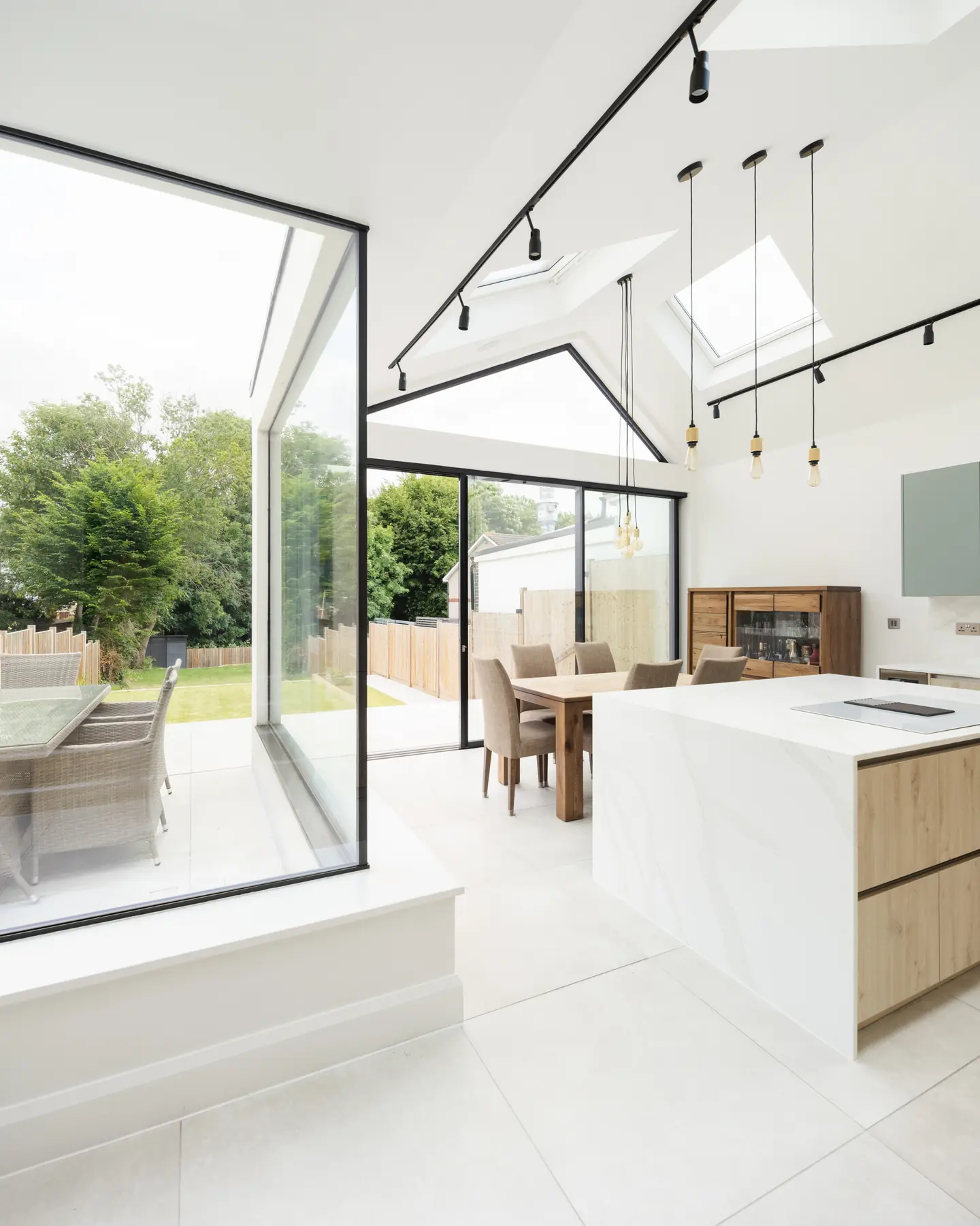 Open-plan kitchen with glass-to-glass corner looking toward the garden