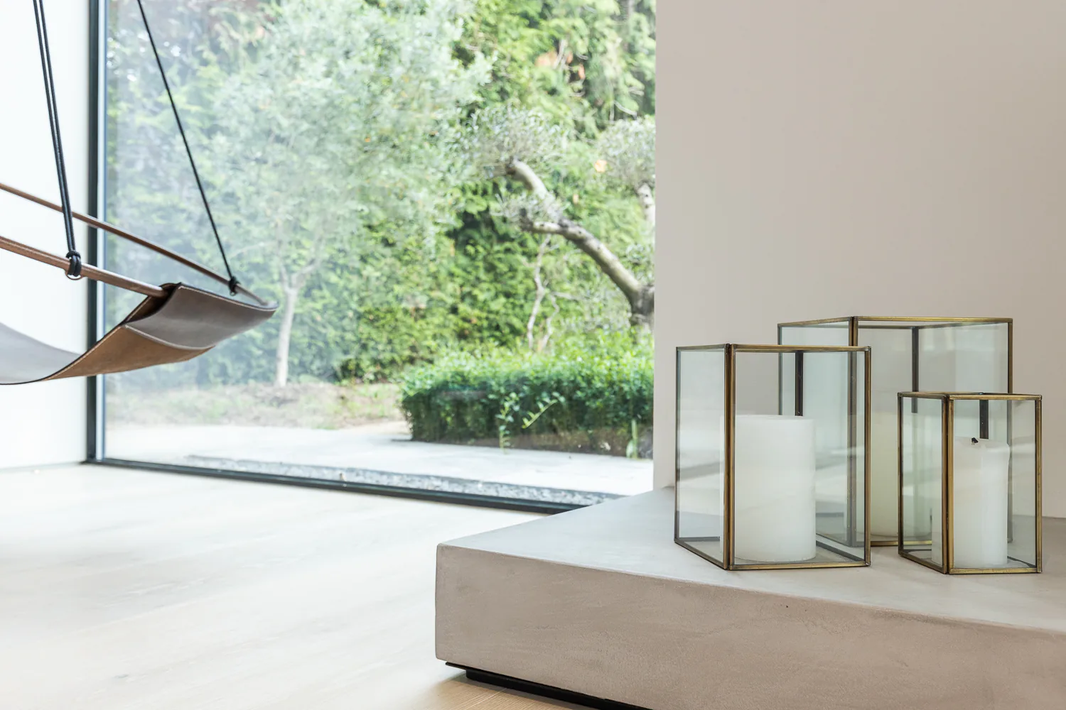 Full-height fixed window framing a leafy garden beside a low living-room table