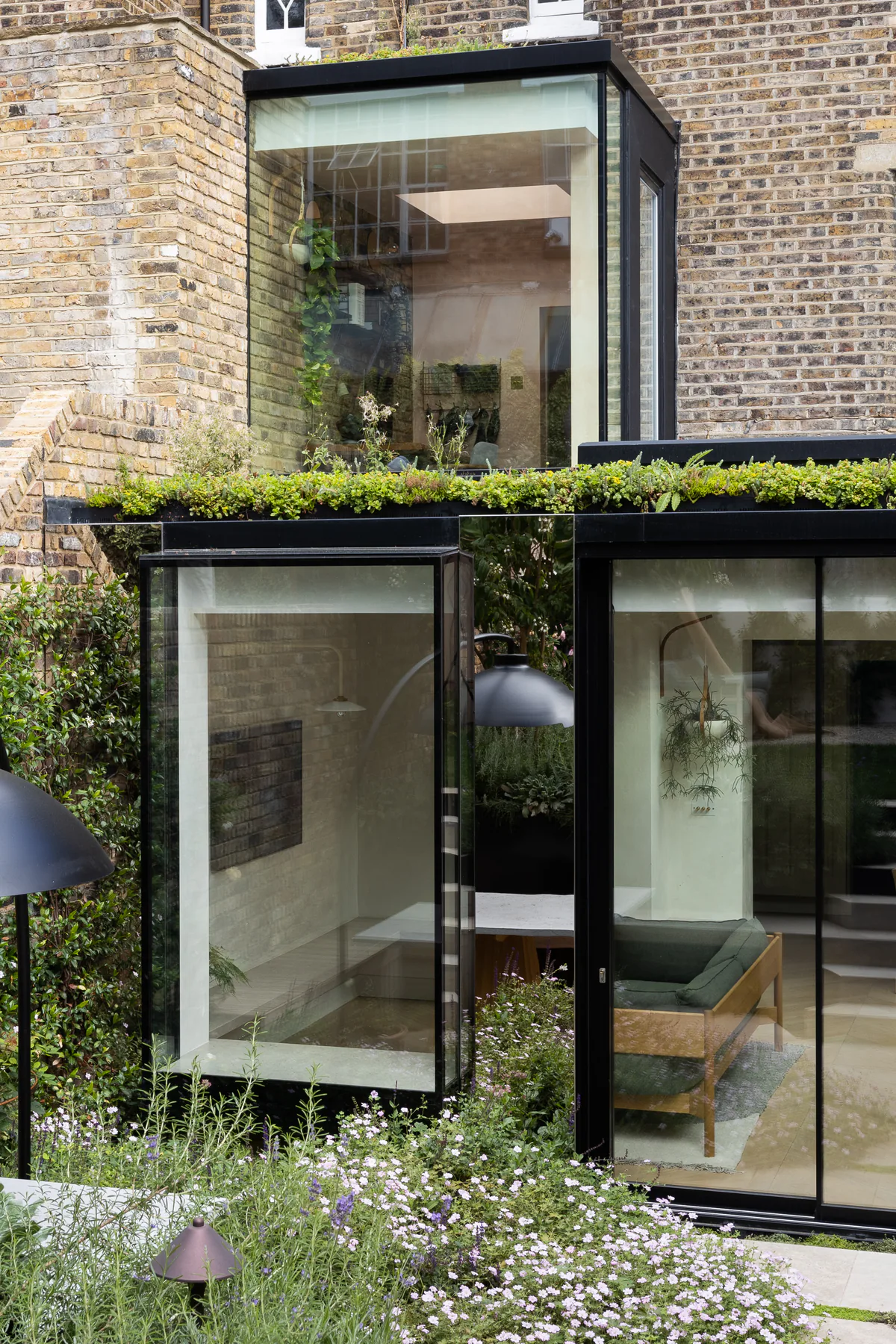 Stacked glass oriel windows projecting above a roof terrace and garden room