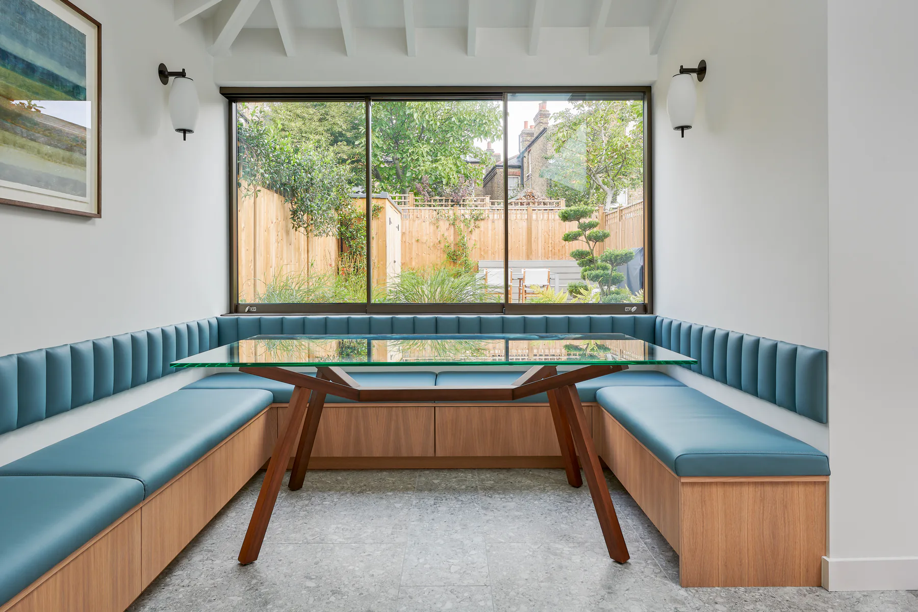 Built-in banquette wrapping a wide aluminium sliding window