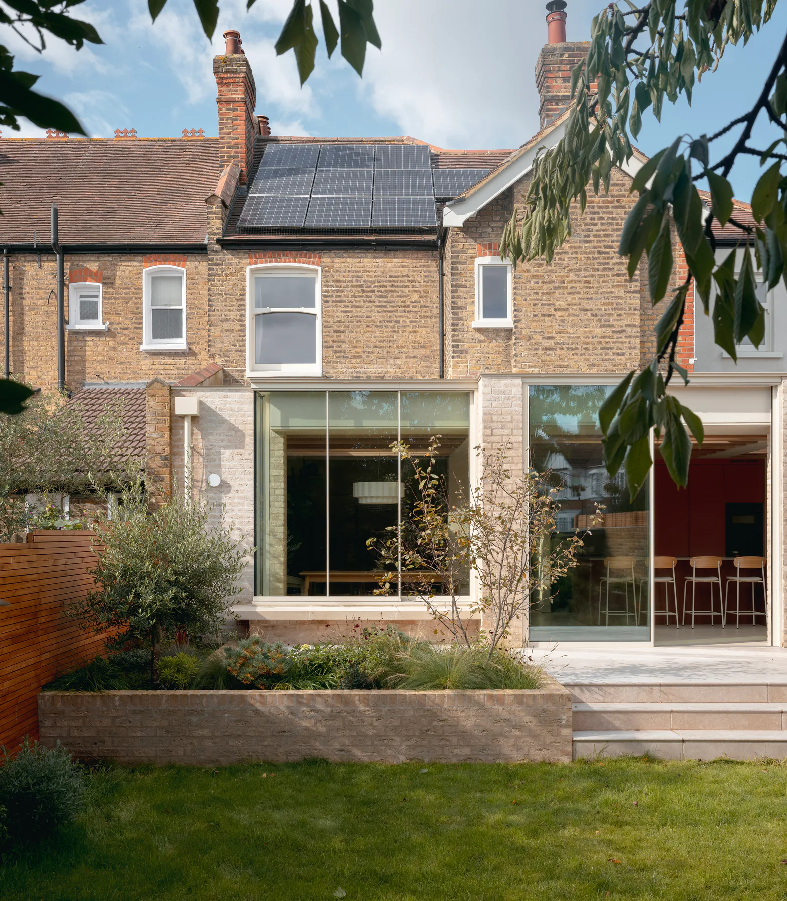 Broad aluminium sliding window across the rear of a brick London home